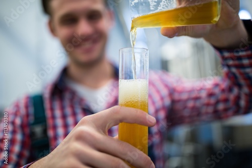 Photography Brewer pouring beer in hydrometer cylinder