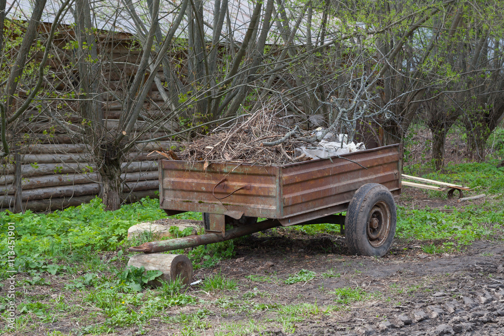 Old rusty cart with wood, wagon with firewood