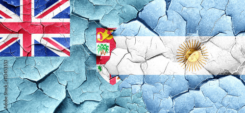 Fiji flag with Argentine flag on a grunge cracked wall