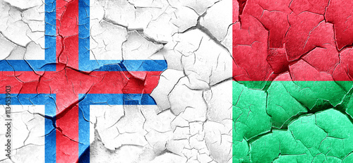 faroe islands flag with Madagascar flag on a grunge cracked wall