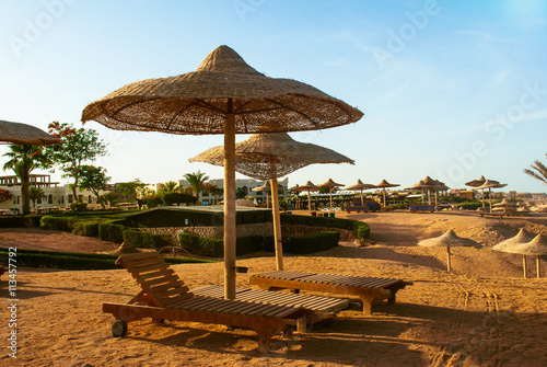 Beach umbrellas and deckchair on the tropical beach © dimazel