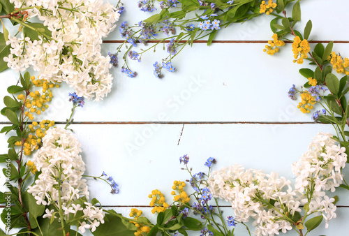 Frame spring flowers blue wooden background flat lay, overhead view © sabyna75