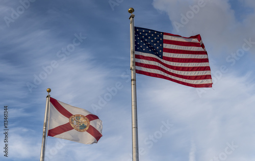 the American and Florida State flag  flying against a blue sky