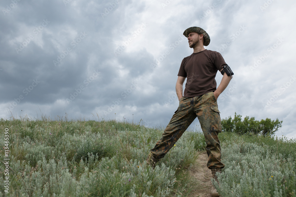 Sure man standing in field at moody sky background Sure man standing in field at moody sky background