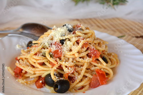 Delicious italian food spaghetti a la puttanesca on a bowl on a table.