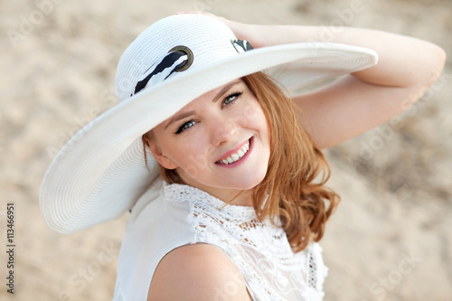 молодая девушка в шляпе на пляже