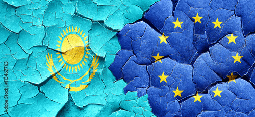 Kazakhstan flag with european union flag on a grunge cracked wal