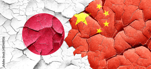 Photography Japan flag with China flag on a grunge cracked wall