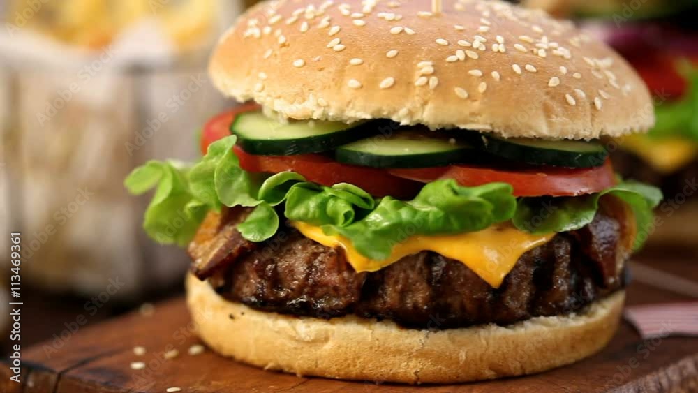 American Burger with bacon,cheese,tomato,lettuce and french fries at a Picnic for 4th of July American Burger with bacon,cheese,tomato,lettuce and french fries at a Picnic for 4th of July