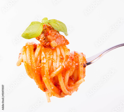 Spaghetti bolognese decorated with basil on a fork