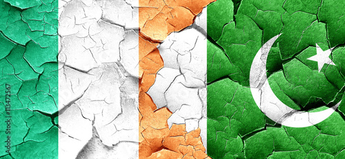 Ireland flag with Pakistan flag on a grunge cracked wall