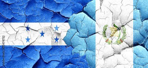 Honduras flag with Guatemala flag on a grunge cracked wall