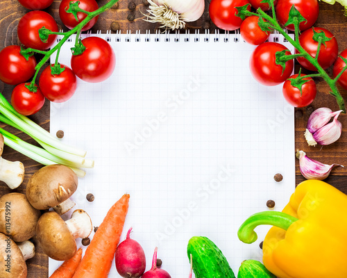 Beautiful background healthy organic eating. Studio photography the frame of different vegetables and mushrooms with a white sheet of paper on the old brown boards with free space
