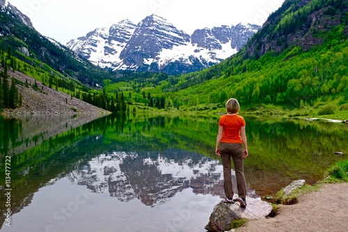 Woman Standing by Lake with Mountains View and Reflection. Maroon Bells near Aspen and Snowmass Village, Colorado State, USA. 