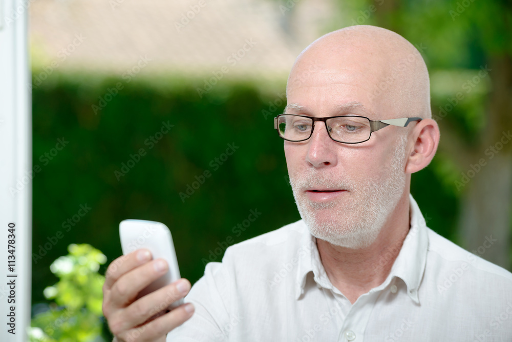 Senior man reading message on smartphone Senior man reading message on smartphone