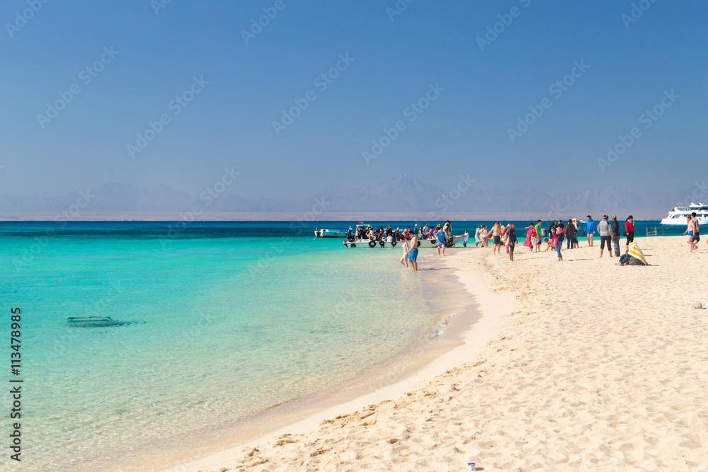 PARADISE ISLAND, EGYPT - FEBRUARY 12, 2016: Tourists at the beach taking of the boats.