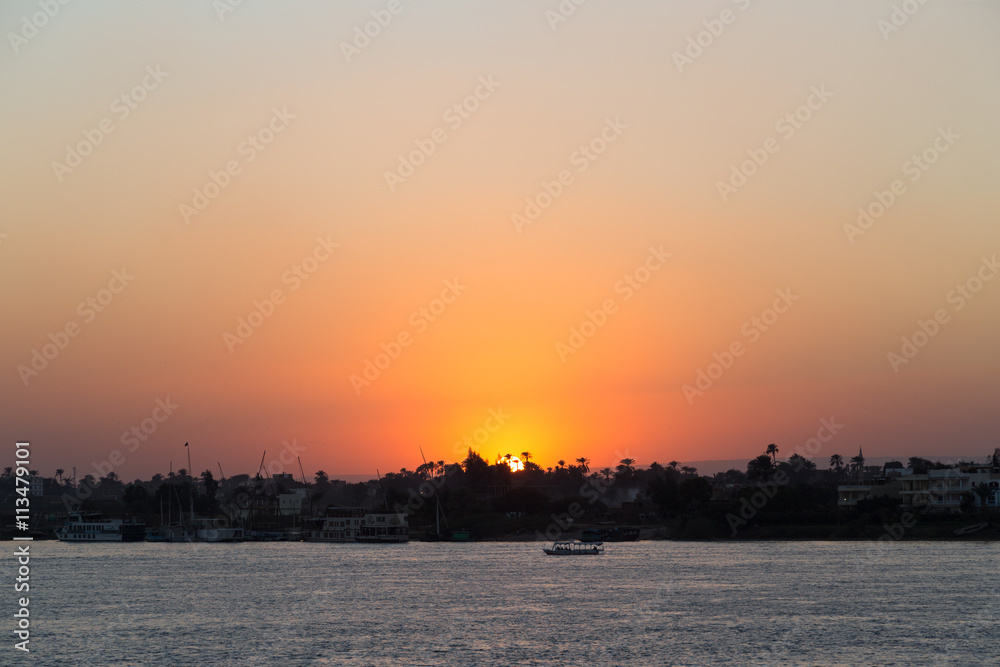 Tourist sailboat at Luxor waterfront during sunset.