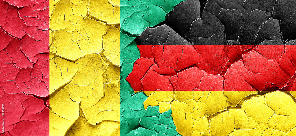 Guinea flag with Germany flag on a grunge cracked wall