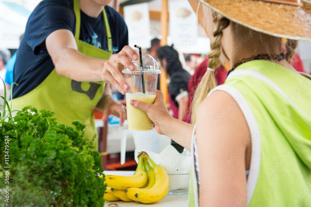 Fresh organic juice is served to a young lady.