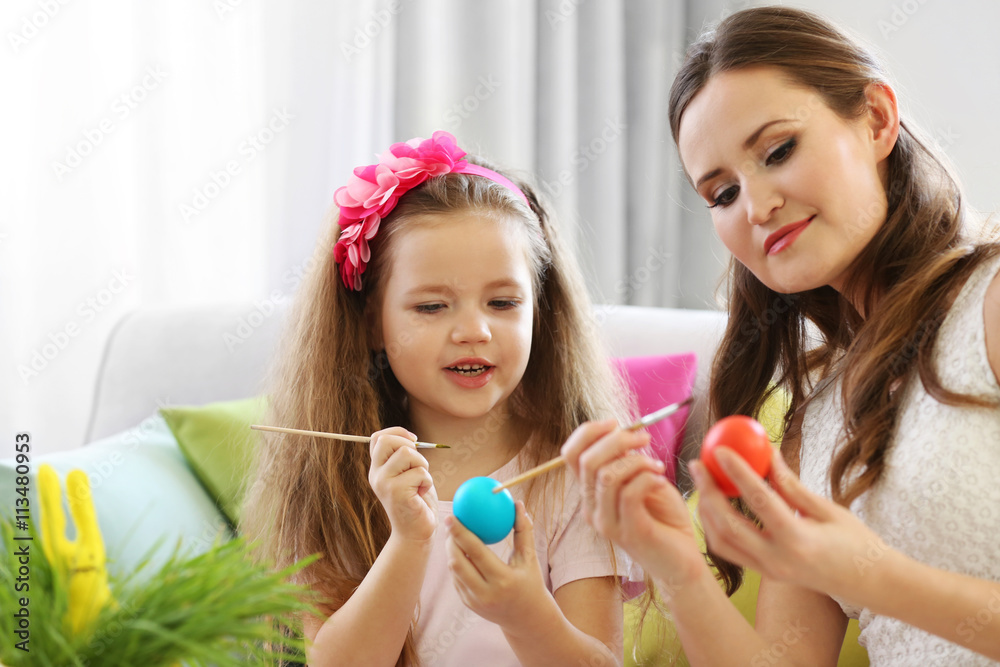 Mother and daughter decorating Easter eggs indoors Mother and daughter decorating Easter eggs indoors