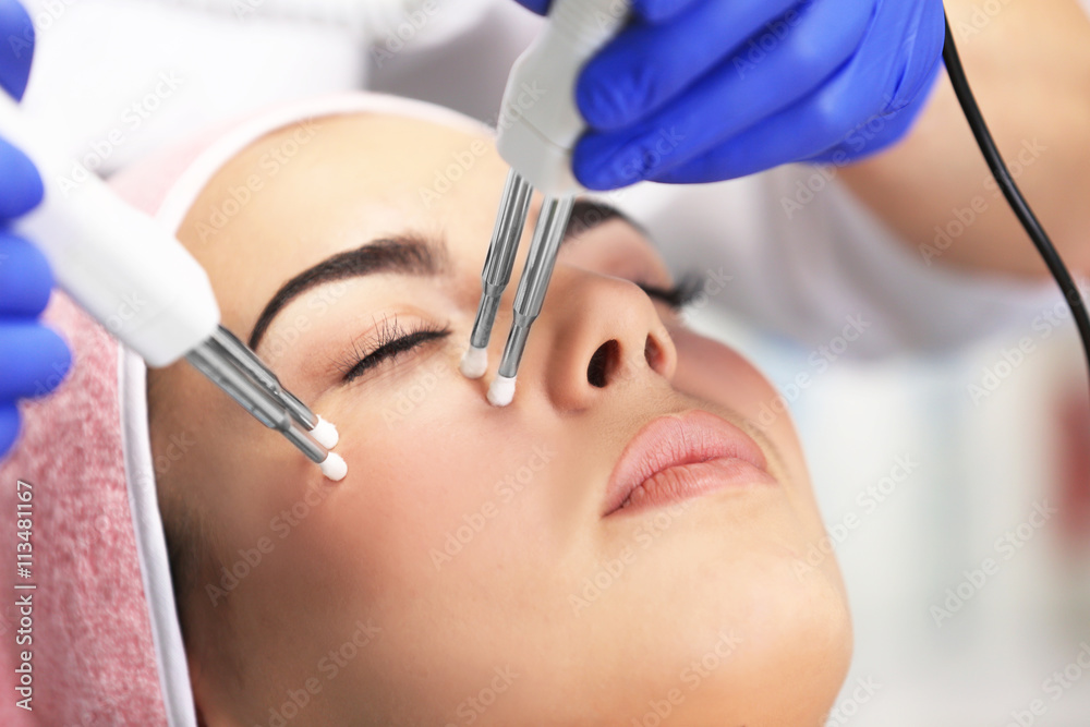 Naklejka premium Young woman having face procedures in a beauty salon