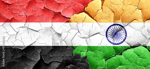 Yemen flag with India flag on a grunge cracked wall