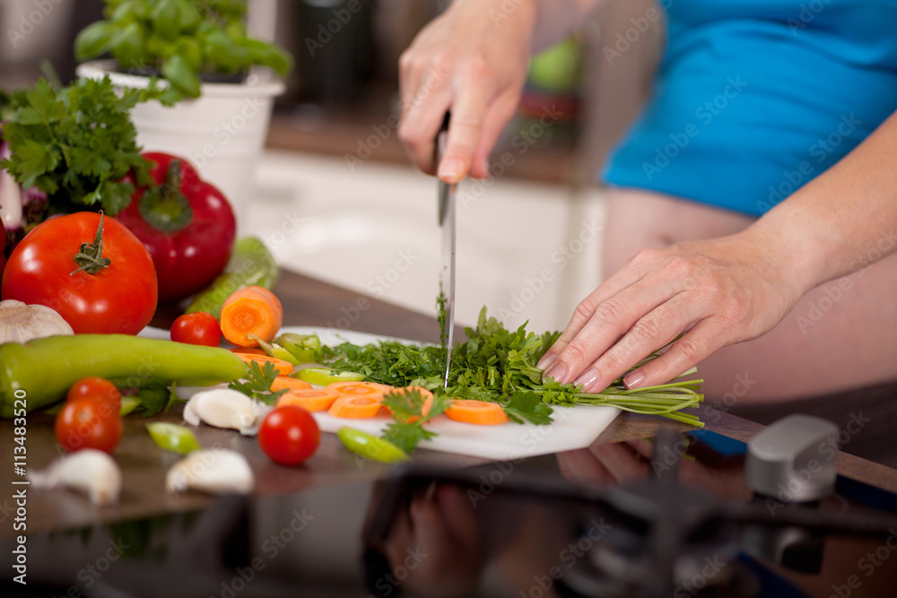 Pregnant woman preparing a healthy meal in the kitchen