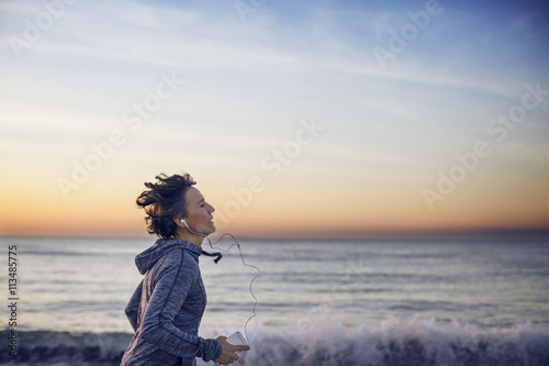 Woman jogging at beach against sky photo