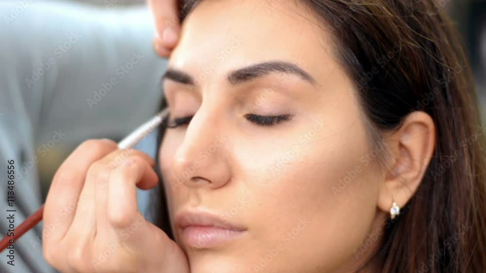 Make-up artist applying eyelash makeup to model's eye. Close up view. Make-up artist applying eyelash makeup to model's eye. Close up view.