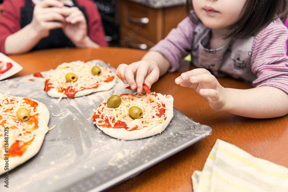 Children preparing mini pizzas Children preparing mini pizzas