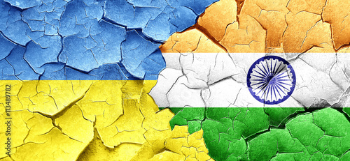 Ukraine flag with India flag on a grunge cracked wall