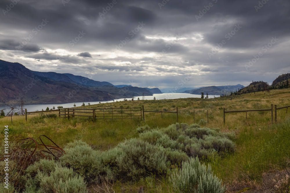 Obraz premium View of the field and a distant river surrounded by mountains. Taken on my recent road trip in British Columbia, Canada.