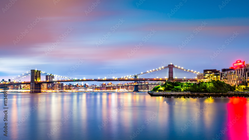 Illuminated Brooklyn Bridge at dusk viewed from Pier2 park in New Yok City