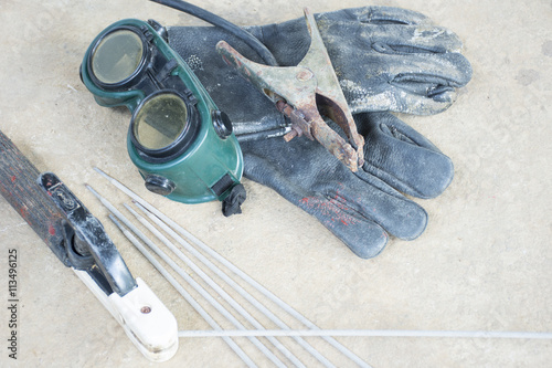 Used welding equipment such as glove and goggles and etc.On cement floor background