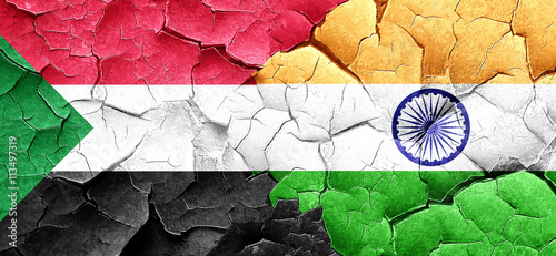 Sudan flag with India flag on a grunge cracked wall