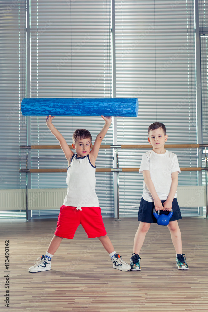 fitness, sport, training lifestyle concept - children in the gym weights and with foam roller