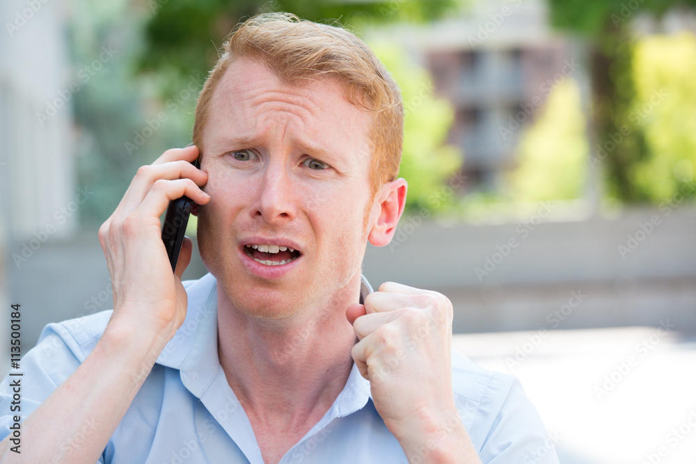 Φωτογραφία Closeup portrait, worried young man in blue shirt talking on phone to someone, l