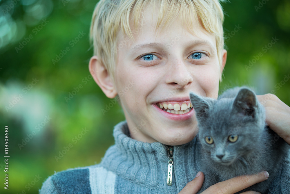 A boy plays with a kitten A boy plays with a kitten