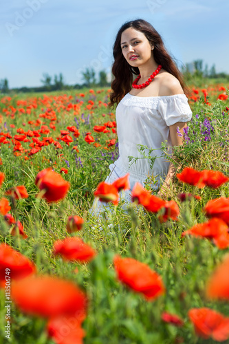 Fototapeta Naklejka Na Ścianę i Meble -  Girl in a field of poppies