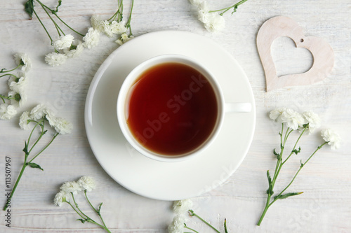 white decorative hearts with flowers on white wooden background with Cup of tea