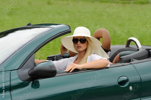 Junge blonde Frau mit Hut und Cabrio