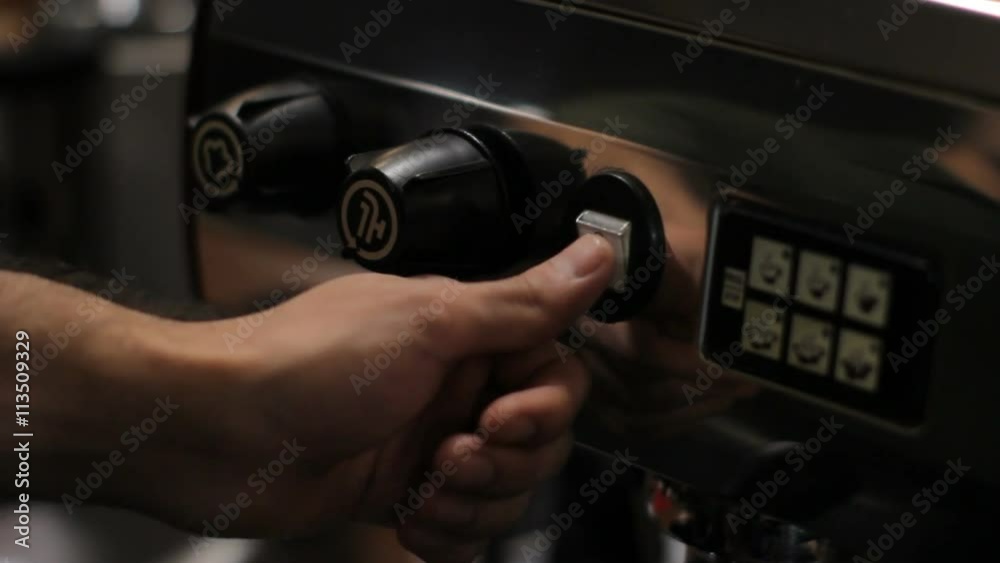 Barista switches on and off the coffee machine. Close up