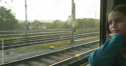 A pensive teenage girl look through the windows while traveling.
