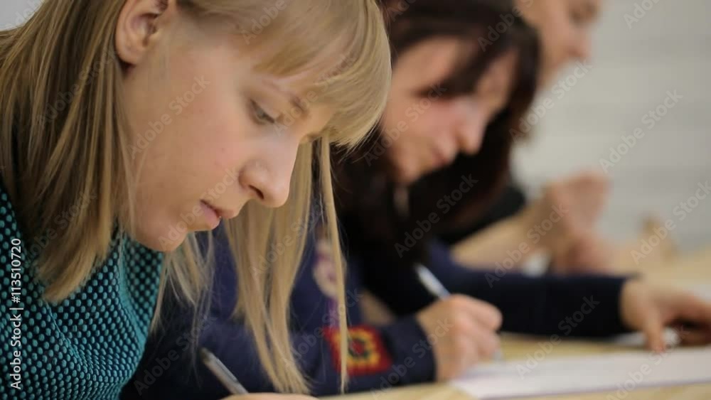 Three women attentively draw sketches on sheet of paper Three women attentively draw sketches on sheet of paper