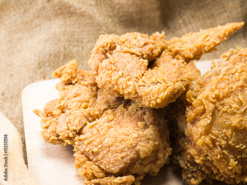 fried chicken on a chopping broad set on a wood background