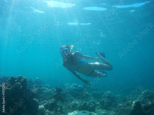 Underwater shot of the woman moving on the breath hold in the depth. Amed village, Bali, Indonesia