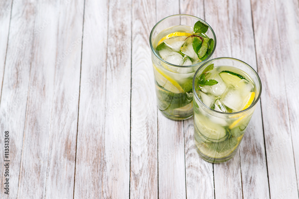 Water with lemon, mint and cucumber on wooden light background. Water Detox. Water with lemon, mint and cucumber on wooden light background. Water Detox.