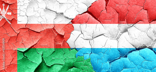 Oman flag with Luxembourg flag on a grunge cracked wall © Argus