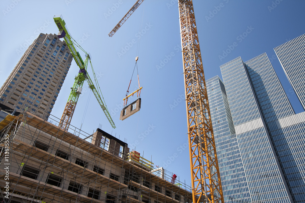 Crane lifting a wall on a construction site