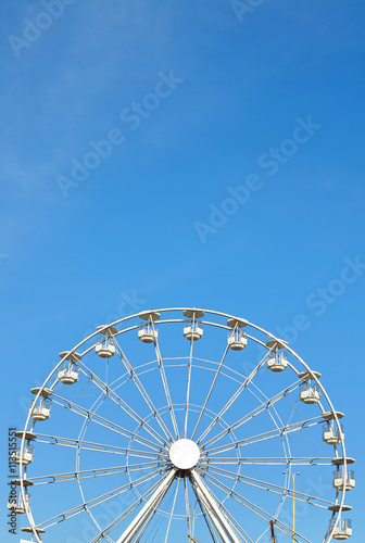 Ferris wheel against blue sky  space for text